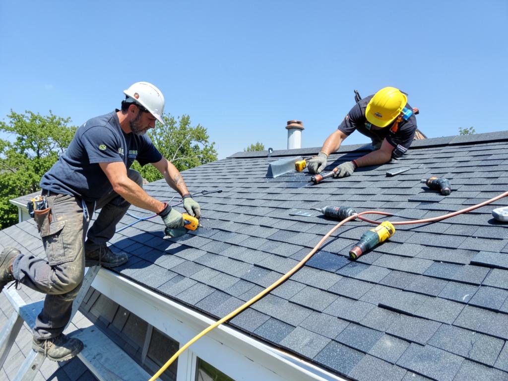Roofing crew installing architectural asphalt shingles on a home